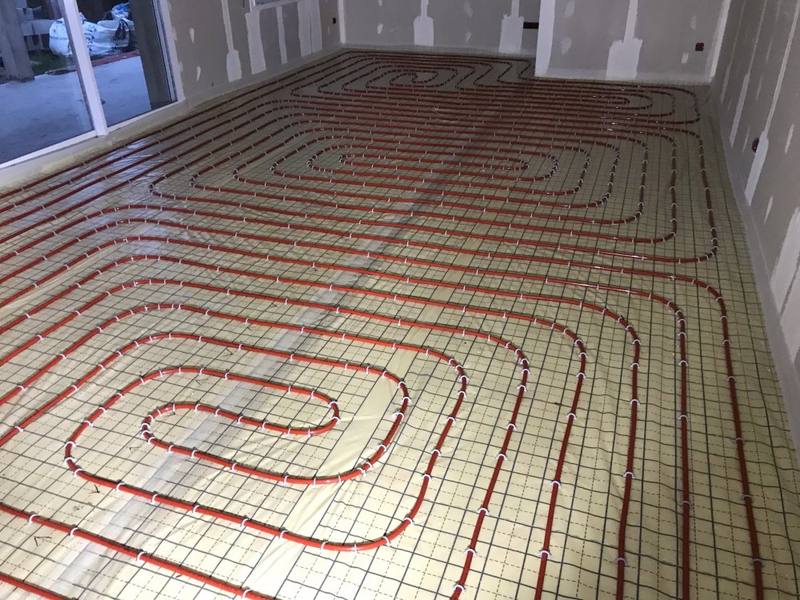 Circuit de plancher chauffant posé sur dalle, tubes rouges en boucles