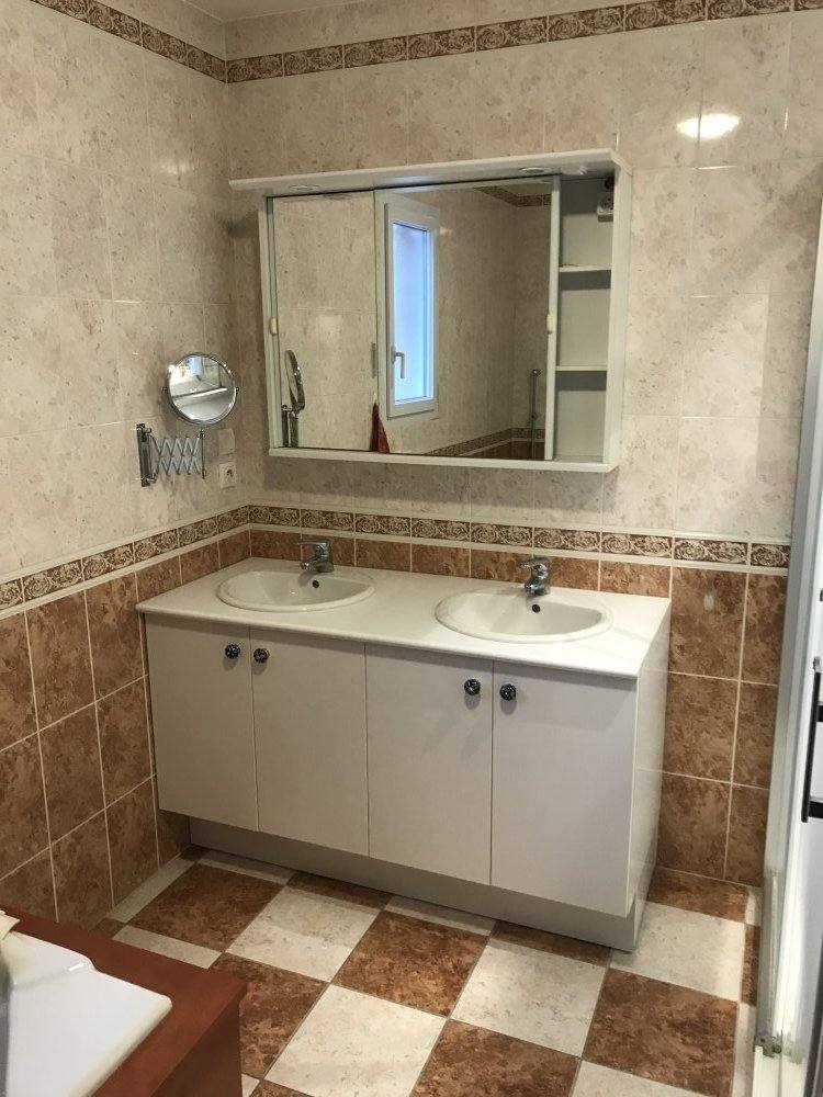 Meuble haut à miroir installé au-dessus du lavabo